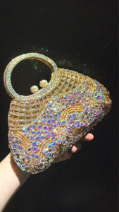 Detailed close-up of hollow gold evening bag with sparkling AB rhinestones and pearls