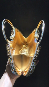 Detailed top view of golden evening clutch with iridescent rhinestones and pearl accents
