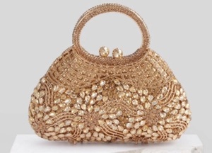 Detail of champagne gold evening bag showing intricate hollow rhinestone floral patterns