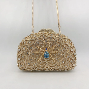 Exquisite gold clutch featuring a blue rhinestone spider detail and fine metal chain strap