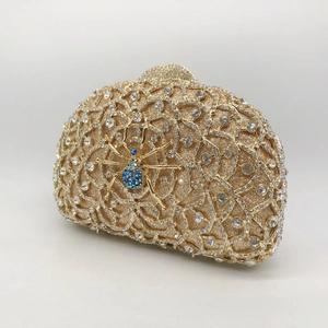 Elegant gold spider clutch bag with shimmering crystals and colorful gemstone detail
