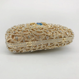 Detail of gold spider clutch evening bag featuring floral rhinestones and blue gemstone