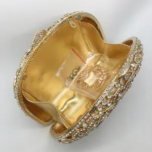 Detail of gold spider clutch open interior with rhinestone inlay and chain strap