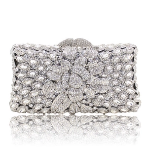 Dettaglio macro del motivo floreale con strass argentati sulla pochette da cerimonia
