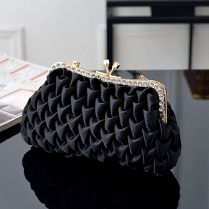 Detail of black pleated satin evening clutch with sparkling rhinestones and gold clasp