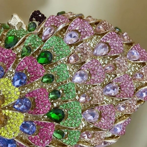 Macro shot of colorful peacock pattern crystals and emerald teardrop stones on evening bag