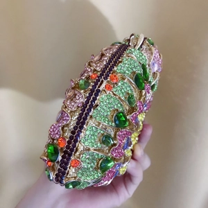 Detailed macro view of an oval evening clutch featuring colorful rhinestones on gold metal