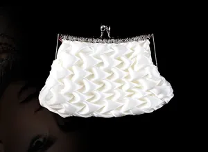 Detail of white satin pleated clutch with sparkling rhinestone silver metal frame closure