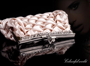 Detailed view of the pleated champagne satin clutch with rhinestone-encrusted metal frame