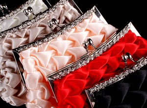 Close-up of satin pleats and crystal-encrusted metal clasps on evening clutch bags