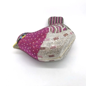 Macro detail of bird-shaped clutch bag encrusted with pink and silver rhinestones