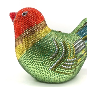 Macro detail of bird-shaped evening clutch bag with colorful rhinestones and crystal plumage