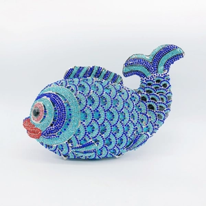 Macro shot of colorful rhinestones on a fish-shaped evening clutch bag with blue crystal scales