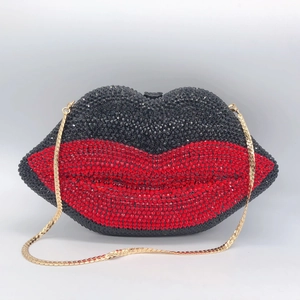 Détail de la pochette lèvres en strass rouge et noir avec une bandoulière chaîne dorée