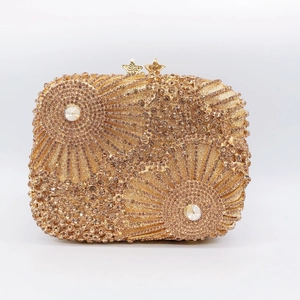 Detailed shot of golden evening clutch bag with sunburst rhinestone pattern and star clasps