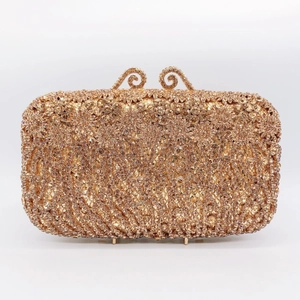 Detailed shot of sparkling champagne rhinestones on luxury gold evening clutch bag