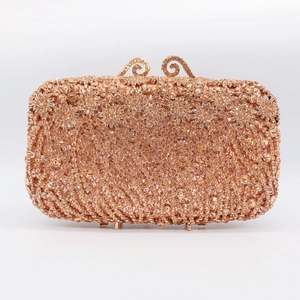 Detailed close-up of rose gold clutch featuring dense rhinestone inlay and ornate clasps