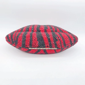 Detailed close-up of red and black zebra-striped rhinestone clutch bag with gold clasp