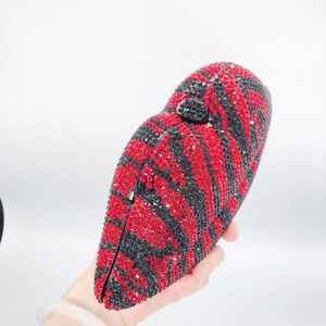 Macro detail of red and black zebra pattern crystal embellishments on the clutch bag