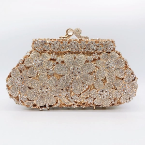 Close-up of golden evening clutch bag with intricate crystal floral patterns and jewel clasp