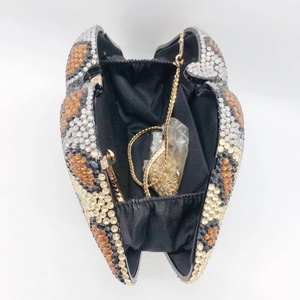 Detail of evening clutch interior with black lining, gold chain, and leopard lip crystals