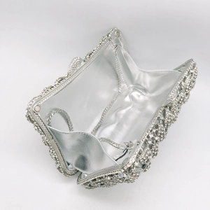Detailed interior of silver rhinestone clutch showing shiny lining and metal chain strap