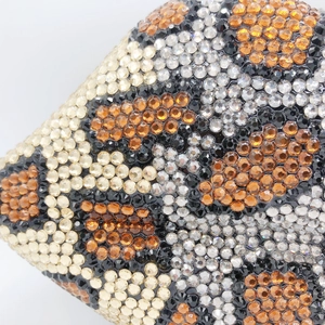 Macro shot of sparkling crystal leopard print pattern on a luxury lip clutch bag