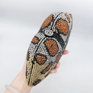 Close-up of a leopard print crystal clutch bag with colorful rhinestones in hand