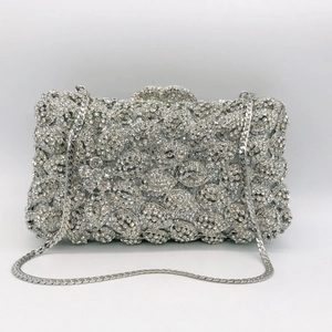 Detailed view of silver evening clutch bag with petal-shaped crystal pattern and chain