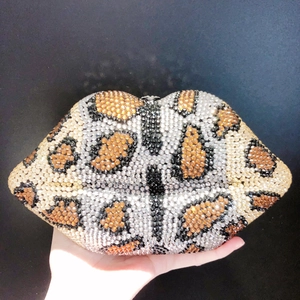 Detailed close-up of leopard print crystal lip clutch bag held in hand for evening party