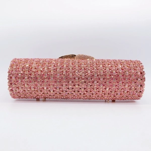 Detailed view of pink rhinestone evening clutch bag with cylinder shape and gold finish