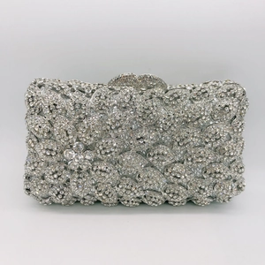 Detailed view of silver stone clutch featuring leaf patterns and a sparkling 3D rhinestone flower