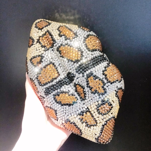 Detailed view of leopard print rhinestones on a handheld evening clutch bag