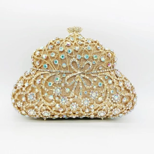 Detailed close-up of luxurious golden clutch bag featuring rainbow crystals and bow design