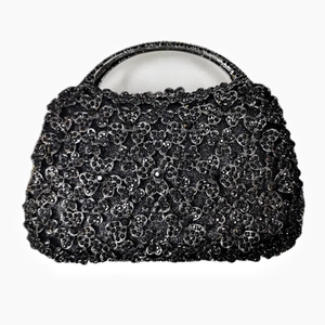 Detailed view of the 3D crystal floral pattern and sparkling metallic top handle on this black evening bag