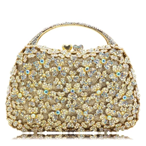 Detailed macro of champagne gold clutch featuring 3D rhinestone floral patterns and gems