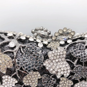Macro view showing intricate vine textures and sparkling crystal vine patterns on a black clutch