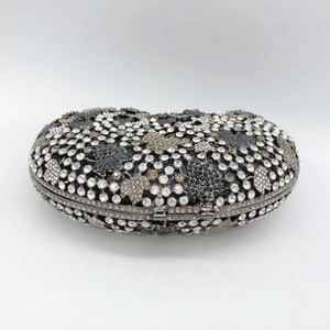 Macro detail of luxury grape leaf clutch bag featuring intricate rhinestones and metal closure