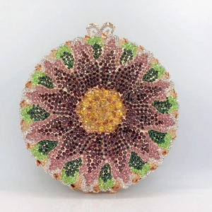 Close-up of sunburst flower pattern on sparkling crystal clutch with heart clasp
