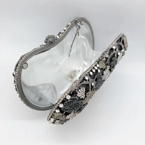Macro detail of luxury crystal evening clutch showing black and white rhinestone floral pattern