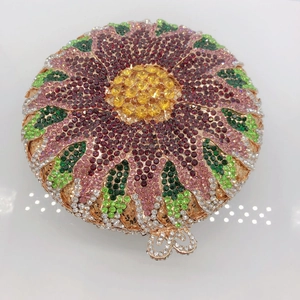 Detailed macro view of a round floral crystal clutch bag with colorful rhinestones