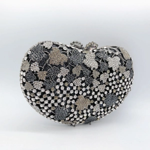 Close-up of heart-shaped evening clutch with grape leaf crystal patterns and jeweled clasp
