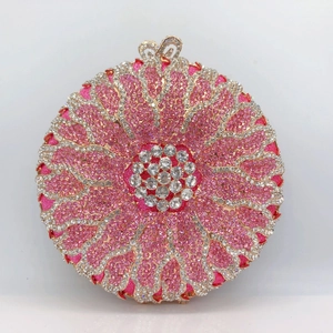Detailed macro of crystal-encrusted floral evening clutch with gold and pink rhinestones