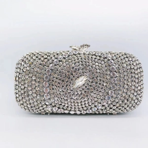 Macro view of silver hard-shell evening clutch with hollow rhinestones and crystal clasp