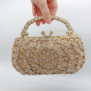 Close-up of golden evening clutch with floral rhinestone patterns and metal handle