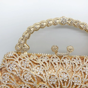 Detailed macro view of gold-tone base with white crystal pavé floral pattern and ring handle