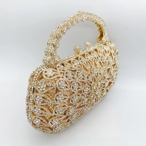 Close-up of golden floral hollow pattern and luxury crystals on evening clutch handle