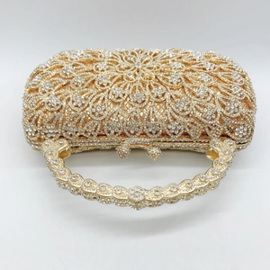 Detail of evening clutch purse featuring golden metal frame and dense rhinestone inlay