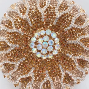 Close-up of floral evening clutch featuring amber rhinestones and gradient crystal details