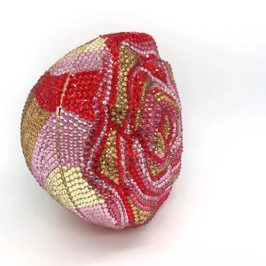 Close-up of rose-shaped luxury clutch purse with red and pink rhinestone crystals